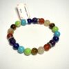 Bracelet en 8 mm, en 3 fois 7 pierres représentant les 7 chakras posé sur fond blanc