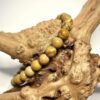 Bracelet en 6 mm en bois fossilisé posé sur morceau de bois