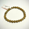 Bracelet en 6 mm en Bois fossilisé posé sur fond blanc