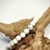 Bracelet en 6 mm en Howlite blanche posé sur morceau de bois