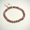 Bracelet en, 6 mm en rhodonite posé sur fond blanc