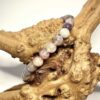 Bracelet en 6 mme en Tourmaline multi posé sur morceau de bois