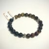 Bracelet homme en pierre d'oeil de tigre, d'oeil de faucon et d'oeil de taureau avec ornement en metal posé sur fond blanc