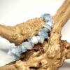 Bracelet bohème en pépite de pierre d'aigues-marines marine posé sur morceau de bois