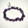 Bracelet bohème en pépite de pierre d'améthyste posé sur fond blanc
