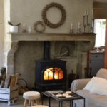 cheminée avec feu et décoration, canapé beige, caisse de bois