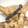 Bracelet en hématite en 6 mm posé sur morceau de bois