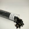 Tube à essai en verre renversé contenant de l'encens en grain Pontifical. On voit l'étiquette Pontifical Encens collé sur le tube et des grains d'encens dépassant du tube.