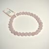 Bracelet en quartz rose 6 mm posé sur fond blanc
