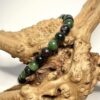 Bracelet en 6 mm de pierre de rubis zoisite posé sur morceau de bois