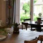 table a manger avec de petites décorations et table ronde de 4 personnes plus foncée