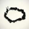 Bracelet bohème en pépite de pierre de tourmaline noire posé sur fond blanc
