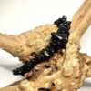 Bracelet bohème en pépite de pierre de tourmaline noire posé sur morceau de bois