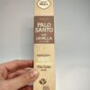 Boite d'encens de palo Santo et vanille de la marque Sagrada madre tenu debout pas une main et sur fond blanc