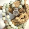 Mala en Amazonite vert avec ornement en métal représentant un Om posé sur morceau de bois