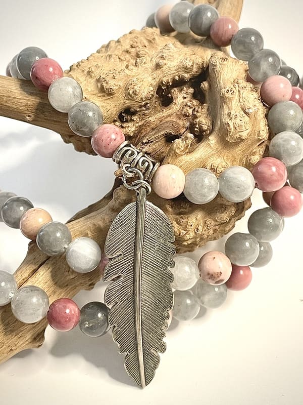 Mala en rhodonite, quartz fumé et agate avec un ornement d'une plume en acier sur morceau de bois