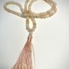 Mala en Aventurine rose avec pompon d'ornement replié en T sur fond blanc