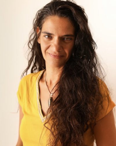portrait de sandra en 3/4 habillé d'un haut jaune et long cheveux bruns tombant sur le côté
